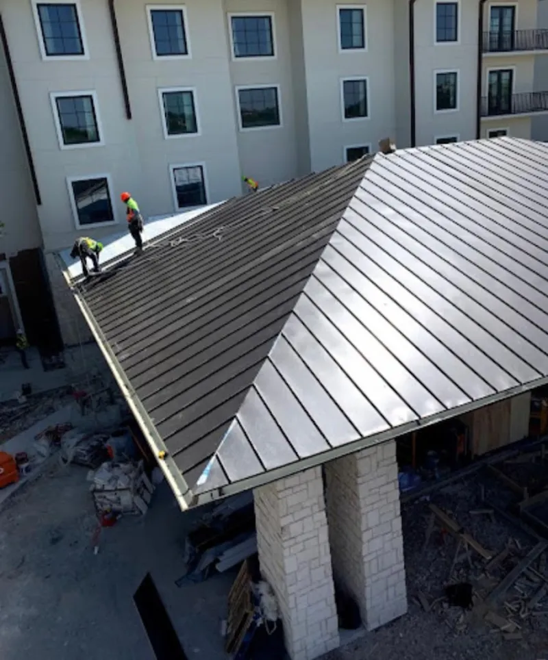Crew installing standing seam metal roof panels on a commercial project in Lower Pottsgrove